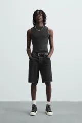 Bermuda de denim de algodón, color verde claro lavado, de corte recto y tiro medio. Presenta cinco bolsillos y cierre frontal con cremallera y botón.