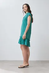 Vestido corto de color rojo con cuello en V, mangas cortas integradas y un detalle de volado en el ruedo. Presenta un diseño de silueta holgada y minimalista.