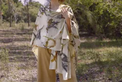 Ruana abierta color crema con estampado de hojas color naranja.