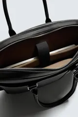 Maletín de diseño ejecutivo con acabado texturizado, cuenta con compartimento principal con cierre, bolsillo frontal con cremallera, compartimento interno para dispositivos electrónicos, doble asa de mano y correa de hombro ajustable y extraíble.