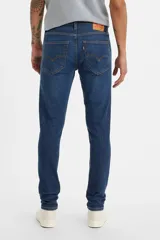 Pantalón de jean azul oscuro, corte skinny taper con tiro medio.