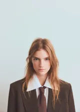 Blazer de corte sastre con diseño de doble botonadura, confeccionado en tejido con patrón de cuadros sutiles. Presenta solapas clásicas, bolsillos con solapa y una estructura entallada que aporta un estilo formal y sofisticado.