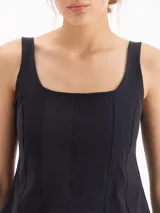 Top negro de inspiración corset confeccionado en poliamida y elastano, con escote cuadrado, breteles anchos, recortes frontales que entallan el busto, escote profundo en la espalda, ruedo semicurvo y cierre metálico en la parte posterior.