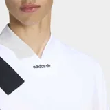 Remera Adidas de estilo retro inspirada en los años 90, con corte holgado y cuello en pico. Presenta un diseño blanco con tres franjas negras diagonales sobre el hombro derecho y logo de la marca bordado en el centro del pecho.