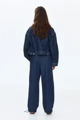 Pantalón tipo jean de corte holgado en denim suave, con diseño de piernas globo, cintura elástica con cordón de ajuste y bajos fruncidos con cordones ajustables.