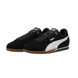 Championes Puma modelo Bella Donna, de diseño urbano y deportivo en color negro con la franja lateral característica en blanco. Presentan una suela de goma color caramelo con excelente tracción y detalles en dorado en los ojales de los cordones.