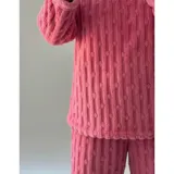 Conjunto de pijama de dos piezas confeccionado en plush suave con textura de ochos. Incluye una remera de manga larga con cuello redondo y un pantalón de corte recto con cintura elástica.
