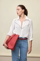 Camisa negra de calce relajado, con mangas 3/4, cuello clásico y cierre frontal con botones. Presenta detalles calados en la parte superior.