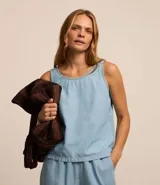 Blusa musculosa de jean color celeste, con cuello redondo y cierre posterior con botón. Confeccionada en una mezcla de lyocell y algodón, presenta un diseño sin mangas y corte recto.