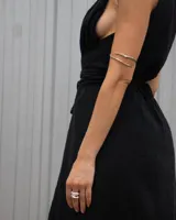 Brazalete rígido de diseño minimalista con forma de espiral, elaborado artesanalmente en bronce y alpaca maciza. Es una pieza ajustable que puede lucirse tanto en el antebrazo como en la parte superior del brazo.