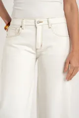 Jean baggy tiro alto color blanco con costuras en contraste color tostado, de diseño abovedado en las piernas.