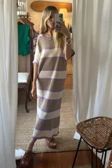 Vestido midi de tejido de punto con diseño de rayas horizontales en tonos beige, marrón y lila. Presenta cuello redondo, mangas cortas y un corte recto y holgado.