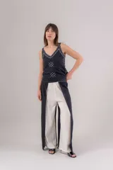 Pantalón de viscosa con cruce tipo pareo que genera tajo en los laterales y bordado.