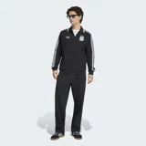 Campera deportiva Adidas de la selección argentina, color negro con diseño retro. Presenta cuello tipo polo con detalles en celeste y blanco, cierre frontal completo, las icónicas tres tiras blancas en las mangas, el logo del trifolio en el pecho derecho y el escudo de la AFA en el pecho izquierdo.