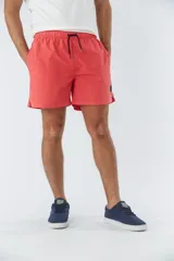 Short de baño liso con cintura elástica y cordón de ajuste. Cuenta con dos bolsillos laterales, un bolsillo posterior y un aplique de logo en goma en la pierna.