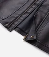 Campera de estilo urbano confeccionada en poliuretano con acabado lavado y textura que imita el cuero. Presenta cuello inglés, cierre frontal con cremallera, vista con botones y bolsillos delanteros amplios.