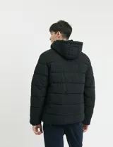 Campera capitoneada de poliéster color negro, con capucha desmontable, cierre frontal y bolsillo en el pecho con cierres engomados y tiradores en color naranja.