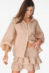 Camisa de lino italiano con estampado a rayas verticales irregulares, de corte holgado, cuello clásico, mangas abullonadas y cierre frontal con botones.