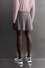 Pantalones cortos de running confeccionados en tejido técnico ligero y elástico, con malla interior. Presentan cintura elástica ajustable con cordón, bolsillo trasero con cierre y aberturas laterales en el bajo.