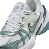 Championes Nike V2K Run de estilo retro-futurista, con diseño en capas de malla y material sintético en tonos beige y gris. Presenta una entresuela robusta con tecnología Cushlon y el logo de Nike en el lateral.