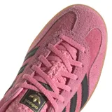 Zapatillas Adidas Gazelle Indoor color rosa con las tres rayas laterales en negro y detalles en azul marino en el talón. Suela de goma color caramelo.