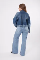Chaqueta de jean celeste con efecto desgastado y flecos en el ruedo.