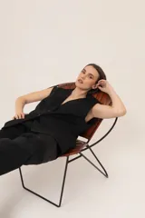 Chaleco marrón con rayas verticales rosas, de corte sastrero y sin mangas.