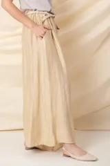 Pantalón italiano ancho color crudo, con cintura elastizada, cinto trenzado y bolsillos laterales.