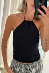 Top tejido color rojo, de punto fino, con cuello halter fruncido y tirantes finos.