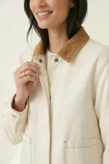 Campera de denim gris con efecto deslavado, cuello camisero de terciopelo negro, bolsillos frontales aplicados y cierre con botones metálicos.