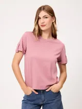 Remera de manga corta color rosado, con cuello redondo y detalles de solapas con botones en las mangas.