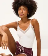 Blusa de pijama seamless color blanco de la marca Lov, confeccionada en poliamida con elastano. Presenta tirantes finos y detalle de encaje en el escote en V.
