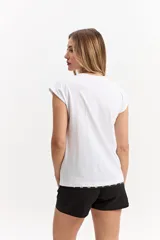 Musculosa oversize de algodón en color gris, con diseño sin mangas y estampado frontal con la palabra "MONACO" sobre franjas verticales naranjas y celestes.