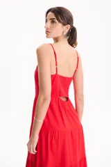 Vestido largo color blanco, confeccionado en lino, con tiras finas regulables, escote recto y falda amplia de corte acampanado con volados escalonados.