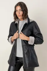 Campera de babylamb color beige con interior de piel sintética al tono. Presenta cierre frontal, capucha desmontable, bolsillos laterales, presillas ajustables en la cintura y cierres en los laterales del ruedo.