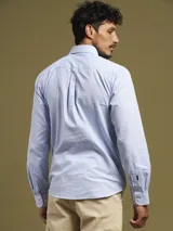 Camisa de vestir a rayas verticales azules y blancas, de corte regular fit y manga larga.