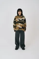 Sweater oversized con estampado camuflado en tonos marrón, verde y negro, de textura suave cepillada. Tiene cuello redondo y corte relajado.