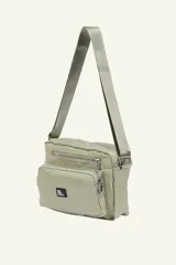 Bandolera color beige con correa larga regulable. Cuenta con múltiples bolsillos con cierre y logo de la marca en etiqueta negra.