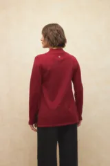 Polera negra de jacquard con cuello alto y aberturas en los laterales y en las mangas.