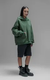 Hoodie oversize de corte crop, color verde, confeccionado en frisa gamuzada de algodón. Presenta capucha forrada y bolsillo canguro frontal.