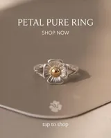Anillo de plata con diseño de flor y detalle central dorado.