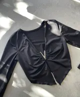 Top marrón de mangas largas con escote en V y detalle de strass en el centro.