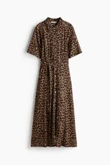 Vestido midi con estampado animal print de leopardo, cuello camisero, botonadura frontal completa, mangas cortas raglán y cinturón de la misma tela para atar en la cintura.