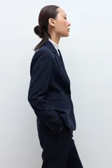 Blazer clásico de corte entallado, color negro, con cierre frontal de un botón, solapas de muesca y bolsillos laterales con solapa.