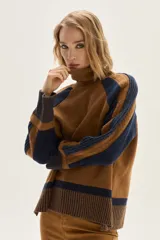 Polera de cuello alto confeccionada en tejido de lana, con diseño bicolor en tonos marrón y azul marino. Presenta mangas raglán, detalles en lurex y cambios de textura en el tejido.