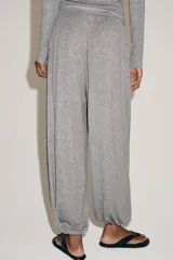 Pantalón bombacho confeccionado en mezcla de lyocell, color gris melange. Presenta tiro medio, cintura elástica con cordón de ajuste, pierna ancha y bajo abullonado con elástico.