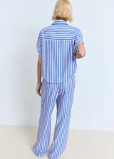 Pantalón de tiro medio con estampado de rayas celestes y rosadas, diseño recto y largo, cintura con goma elástica y dos bolsillos laterales.