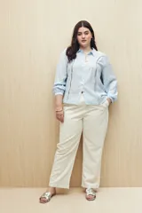 Camisa blanca de manga larga con cuello clásico y botones de nácar. Presenta detalles calados en el frente.