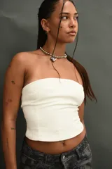 Top tipo corset o bandeau color blanco hueso, ajustado al cuerpo, sin tirantes.