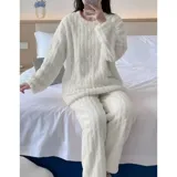 Conjunto de pijama de dos piezas confeccionado en plush suave con textura de ochos. Incluye una remera de manga larga con cuello redondo y un pantalón de corte recto con cintura elástica.